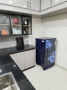 a kitchen with a blue refrigerator with blue flowers on it at Just Launched Cute Studio 2 BHK Flats in Kondapur Near Botanical Garden & Sarath City Capital Mall in Kondapur +37 photos