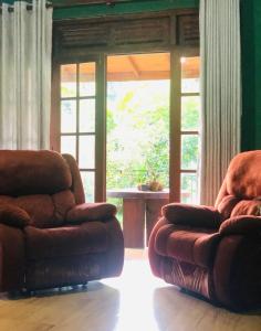 un soggiorno con due sedie e una grande finestra di Summerfield a Kandy