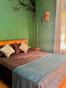 un letto in una camera da letto con parete verde di Summerfield a Kandy