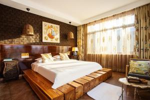 a bedroom with a large bed with a wooden frame at Six-rafter Hall designer hot spring inn in Shangzhi