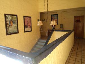 a staircase in a room with two lamps and pictures on the wall at Hotel Mercurio - Gay Friendly in Puerto Vallarta