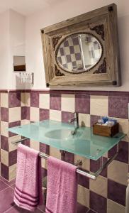 a bathroom with a glass sink and a mirror at Hostal Raices in Puebla de Sanabria