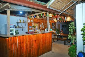 a bar in a restaurant with a person sitting at a table at Ananas Guesthouse in Moalboal