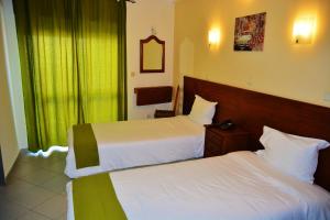 a hotel room with two beds and a window at Residencial A Doca in Faro