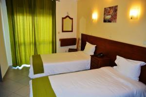 ein Hotelzimmer mit 2 Betten und einem Fenster in der Unterkunft Residencial A Doca in Faro