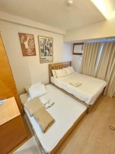 a room with two beds and a window at Steff's Condo 1708 one bedroom at Centrio Tower in Cagayan de Oro