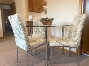 two chairs and a glass table with a plant on it at Stay on Lachlan in Cowra