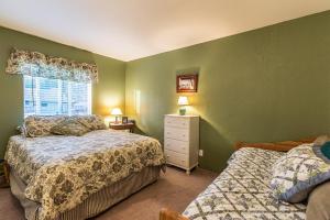 ein grünes Schlafzimmer mit 2 Betten und einem Fenster in der Unterkunft Spacious cozy chalet huge deck over seasonal creek in Big Bear City Airport