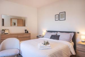 a bedroom with a bed with a chair and a mirror at Cortona Skyline Retreat in Cortona
