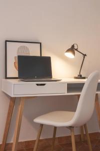 a white desk with a laptop and a chair at Cortona Skyline Retreat in Cortona +31 photos