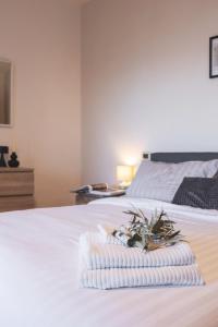 a white bed with a towel and flowers on it at Cortona Skyline Retreat in Cortona