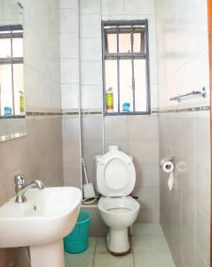 a bathroom with a toilet and a sink at Honey Suite Two Bedroom Master & Suite Apartments in Nairobi +39 photos