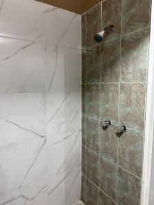 a bathroom with a shower with marble tile at Departamento enteró en Mayorazgo in El Gallinero