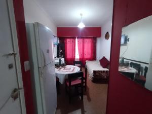a room with two beds and a kitchen with red walls at Departamento 3am centro in Mar del Plata