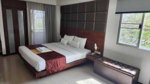 a bedroom with a large bed in a room at Collection O The Bangkok Cha Cha Suite in Bangkok