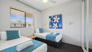 una piccola stanza con due letti e una finestra di Ocean Parade 9 - Cafes, Stroll to beach, BBQ, Pool a Coffs Harbour
