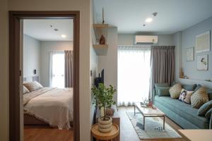 a bedroom and a living room with a bed and a couch at Cozy River 1B1B -Sky River- Infinity Long Rooftop Pool in Chiang Mai +28 photos