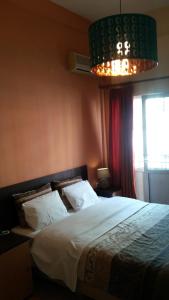 sypialnia z dużym łóżkiem i żyrandolem w obiekcie Alexandria Hotel w Salonikach