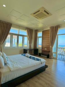 a bedroom with a large bed with windows at Căn Hộ Ocean Vista-Mũi Né-Phan Thiết in Phan Thiet +167 photos