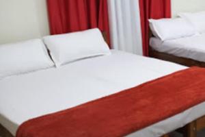two twin beds in a room with red curtains at Hasiru Farms Homestay by StayApart in Mudigere +9 photos