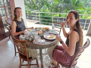 two women sitting at a table eating food at Ocean Beauty Guest House in Negombo