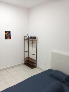 a bedroom with a bed and a shelf in the corner at mazya homestay in Malacca