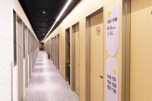 a hallway of halls with doors and signs on the walls at wohkoon Youth Hostel Sanlitun Taikoo Li Branch in Beijing