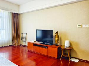 a room with a flat screen tv on a table at Tianjin Crown International Apartment in Tianjin