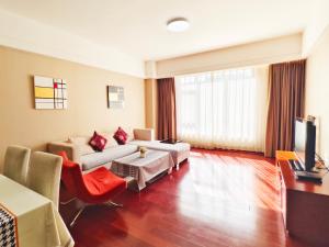 a living room with a couch and a tv at Tianjin Crown International Apartment in Tianjin