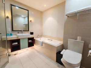 a bathroom with a sink and a toilet and a mirror at Tianjin Crown International Apartment in Tianjin