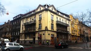 duży żółty budynek na ulicy miejskiej z samochodami w obiekcie Apartments Downtown w Zagrzebiu