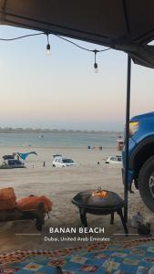 Madīnat an NahḑahにあるAbu Dhabi Caravansの海の中の人々とグリルしたビーチ