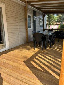 a patio with a table and chairs on it at Mobil home 253 Camping La Réserve 4 étoiles à Gastes in Gastes +8 photos