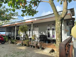 a house with a tree in front of it at Pondok Putri Tunggal syariah in Ujunggenteng