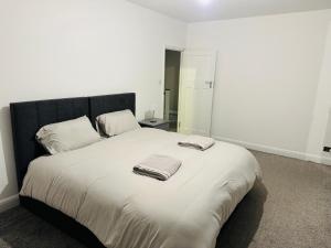 a white bed with two towels on top of it at Elegant 5 Bed house Free parking Free WiFi in Shirley +14 photos