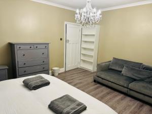 a bedroom with a bed and a couch at Elegant 5 Bed house Free parking Free WiFi in Shirley