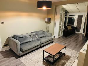 a living room with a couch and a table at Elegant 5 Bed house Free parking Free WiFi in Shirley