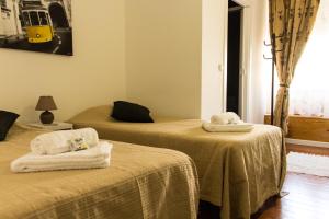two beds with towels on them in a room at Guest House Guerra Junqueiro II in Lisbon