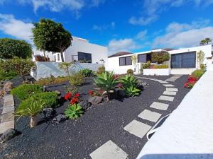 Un jardín frente a una casa con plantas. en Villa Lilli, en La Asomada