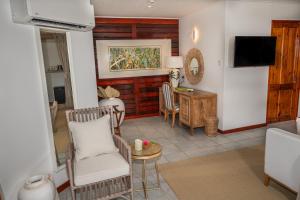 een woonkamer met een stoel en een tafel bij Acajou Beach Resort in Baie Sainte Anne