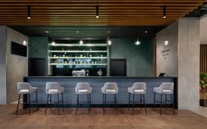 a bar with white stools in a lobby at Hunguest Hotel Béke in Hajdúszoboszló +42 photos