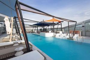 a swimming pool with chairs and umbrellas on a building at SO/ Uptown Dubai in Dubai