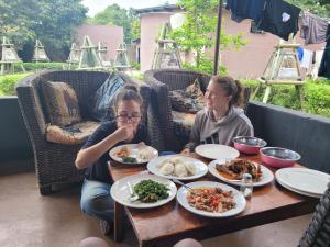 two girls sitting at a table with plates of food at Lusaka Backpackers in Lusaka