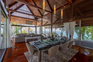 Un comedor con una mesa larga y sillas. en 33 - The Cove in Laem Singh Beach, en Surin Beach 31 fotos más