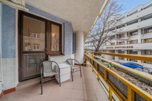 a balcony with two chairs and a table and a window at HUGE APARTMENT next to train station close to the city center in Staré Mesto