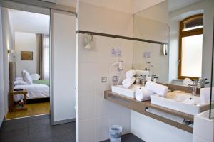 La salle de bains est pourvue de 2 lavabos et d'un miroir. dans l'établissement Le Manoir d'Agnès, à Tarascon-sur-Ariège