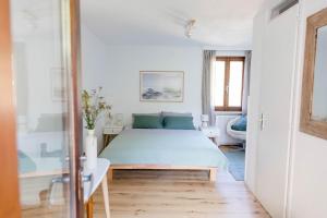 a white bedroom with a bed and a window at BnB Casa Bellavista Sant Abbondio 6577 Ranzo in Gerra