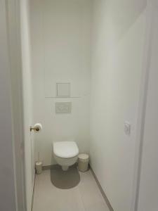 a bathroom with a toilet in a white room at Les Casas de Sísi in Chassieu