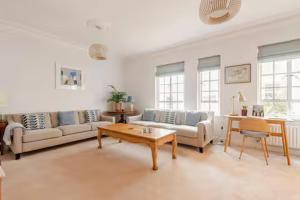 ein Wohnzimmer mit Sofas und einem Couchtisch in der Unterkunft Nordic Regency Apartment in Cheltenham