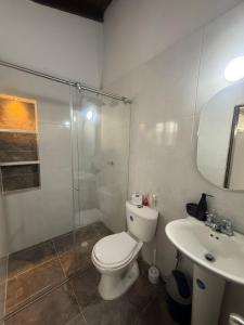 a bathroom with a toilet and a sink and a shower at Habitación pequeña a una cuadra de Ventura Plaza in Cúcuta +4 photos
